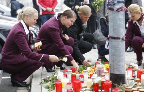 Germanwings employees cry as they place flowers and lit candles outside the company headquarters in Cologne Bonn airport, Germany March 25, 2015.