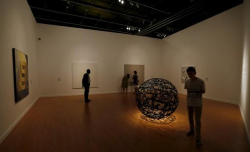 Tourists look at artwork from the Seeing Through Light selections from the Guggenheim Abu Dhabi collection at the Manarat Al Saadiyat Gallery in Abu Dhabi November 27, 2014. Reuters