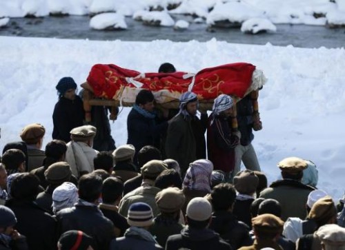 Afghan men carry the body of an avalanche victim for a burial ceremony in Panjshir province, February 26, 2015. 
