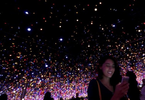 A tourist uses her phone inside the Infinity Mirrored Room by Yayoi Kusama from the Seeing Through Light selections from the Guggenheim Abu Dhabi collection at the Manarat Al Saadiyat Gallery in Abu Dhabi November 27, 2014. Reuters