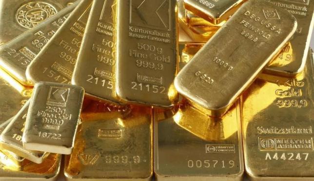 Gold hit by strong US data, but poised for weekly gain