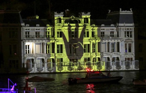 The Rabia sign is projected on the Egyptian Consulate during a protest against an Egyptian court's decision to sentence deposed President Mohamed Mursi to death, in Istanbul