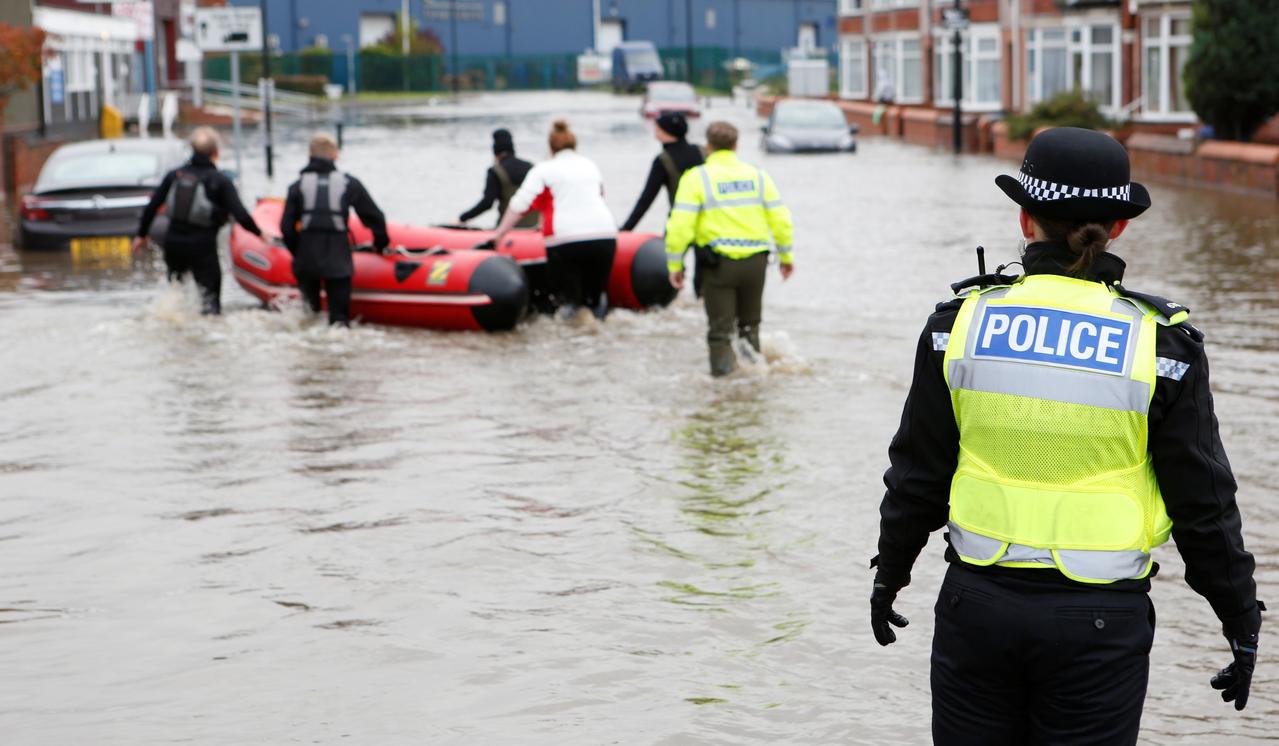 Woman dies as downpours bring floods across central and northern England
